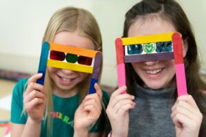 Two girls smile with 3D glasses.