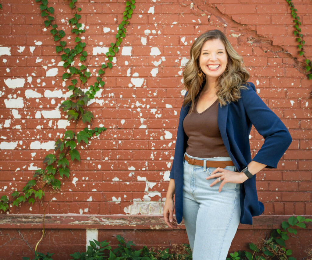 Kimberly Stern poses in front of a red brick wall. 
