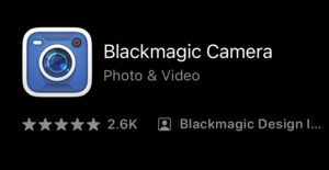 A screenshot of an icon of the Blackmagic Camera phone app. The icon is a blue, square-shaped camera. Text to the right of the icon says "Blackmagic Camera: Photo & Video."