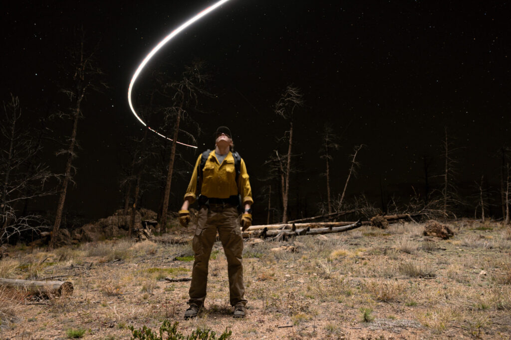 Environmental portrait of Jasper Kehoe, a wildland firefighter and biomedical sciences student at CSU, wanders the Cameron Peak fire burn scar up the Poudre Canyon.